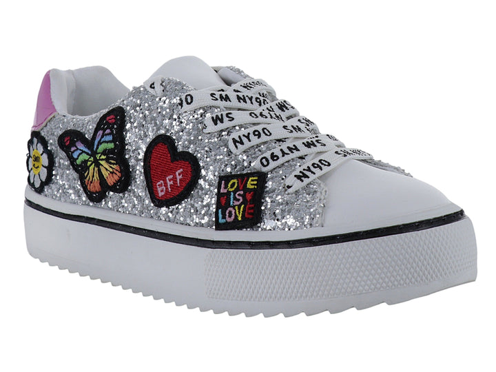 Tenis infantiles color plata con glitter, adornos de mariposa y corazón, y suela blanca.