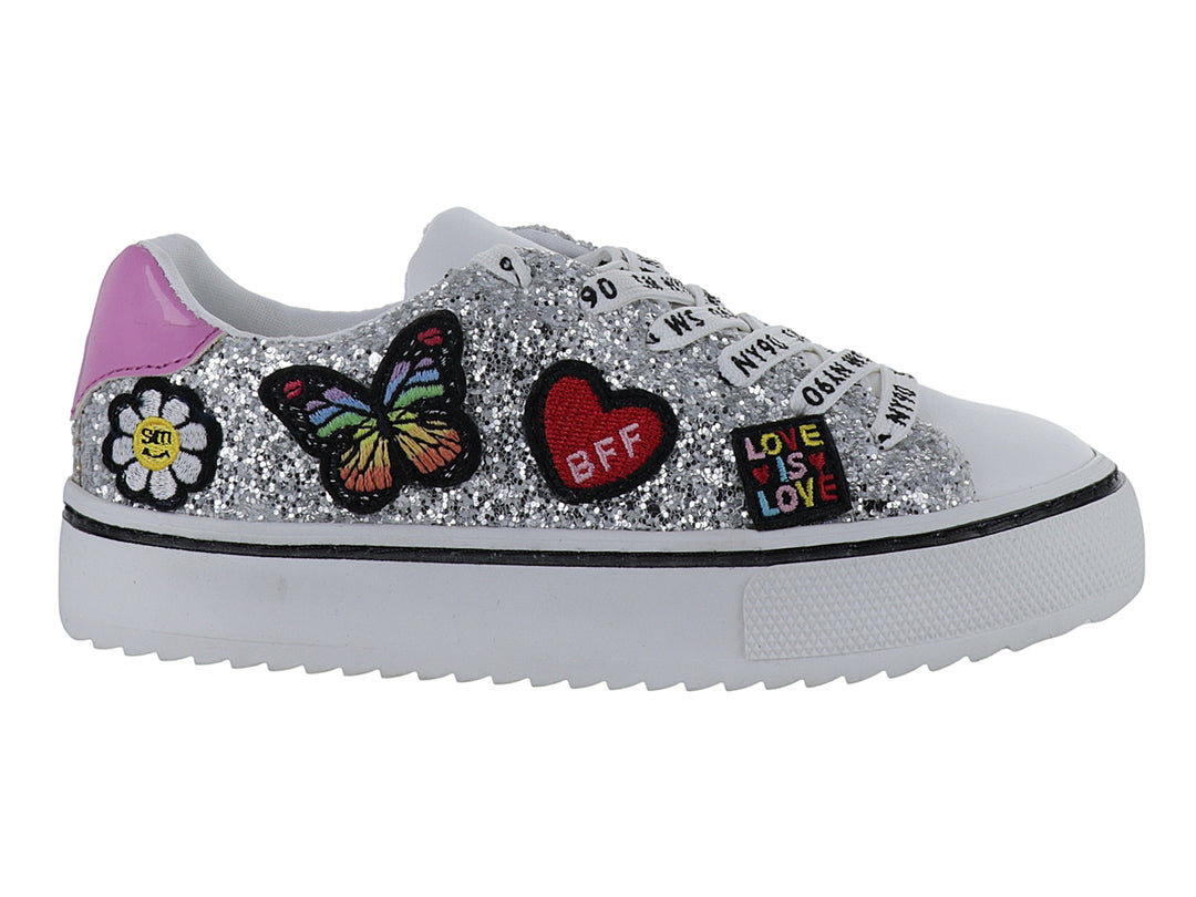 Tenis infantiles color plata con glitter, adornos de mariposa y corazón, y suela blanca.