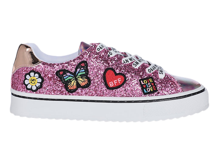 Tenis infantiles rosa con glitter, adornos de mariposa y corazón, y punta holográfica.