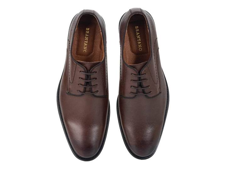 Zapato formal de cuero color café con cordones y suela negra.