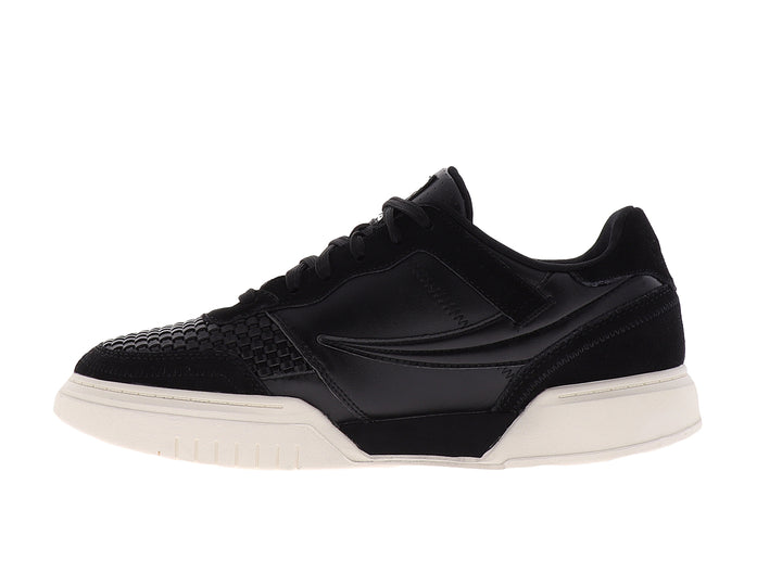 Tenis FILA color negro con suela color crema, diseño deportivo casual.