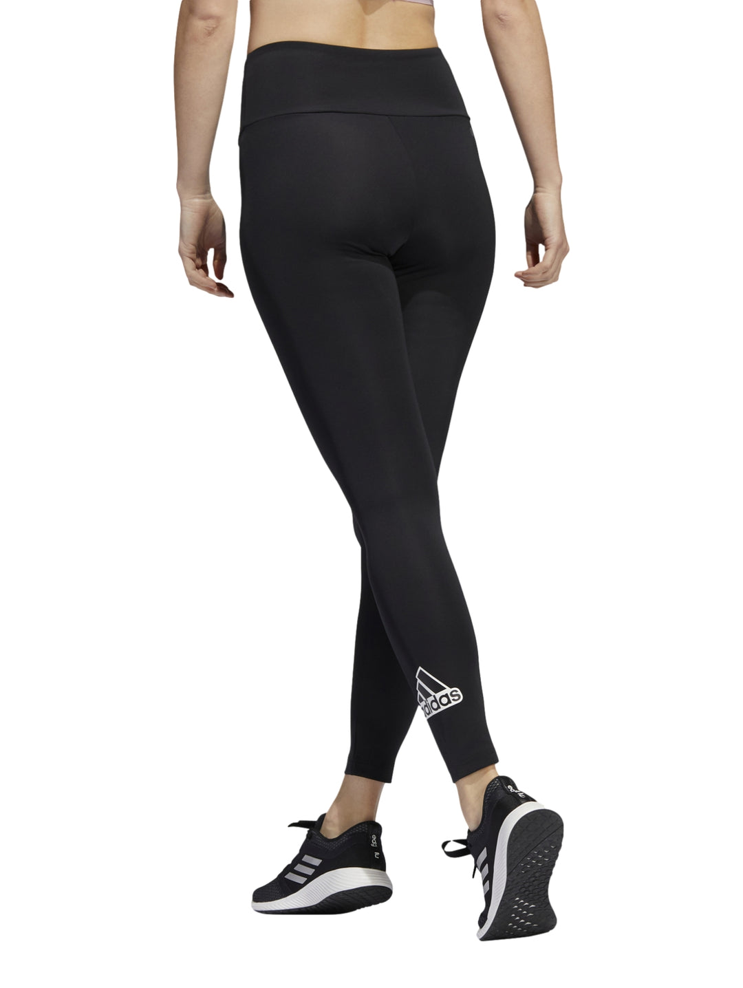 Mujer vistiendo leggings deportivos Adidas de color negro, ajustados y de cintura alta.