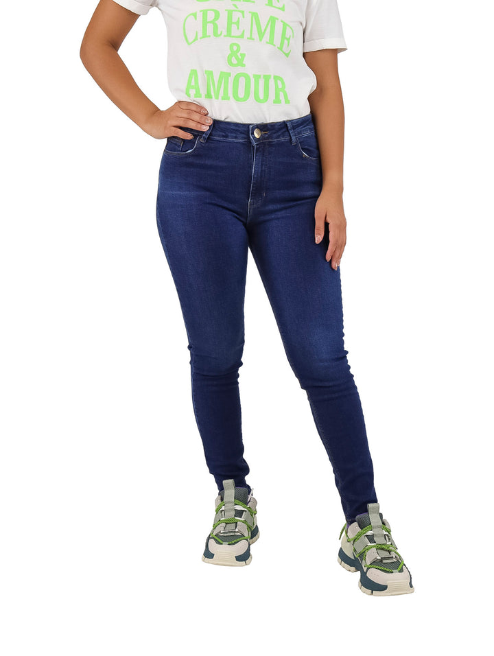 Mujer vistiendo pantalones jeans ajustados de color azul oscuro.