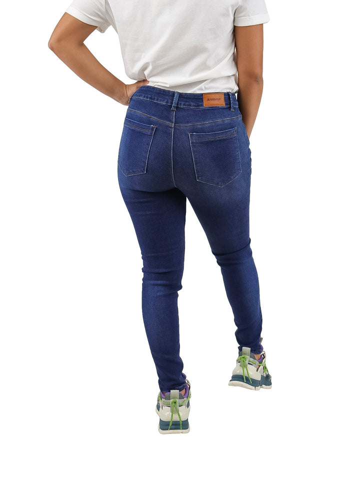 Mujer vistiendo pantalones jeans ajustados de color azul oscuro.