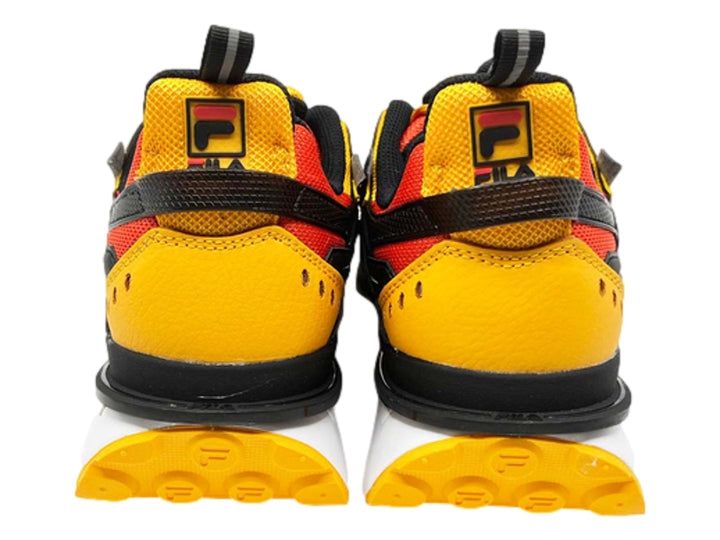 Tenis deportivos FILA en colores naranja, amarillo y negro con suela blanca y amarilla.