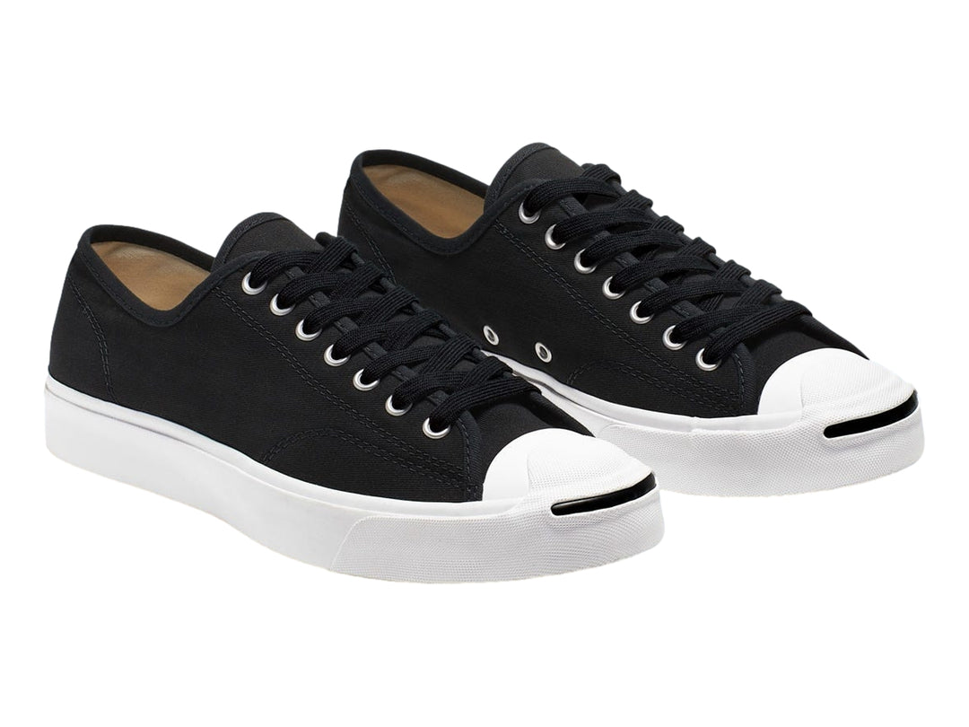 Tenis Converse Jack Purcell de color negro con suela y punta blanca, vista lateral.