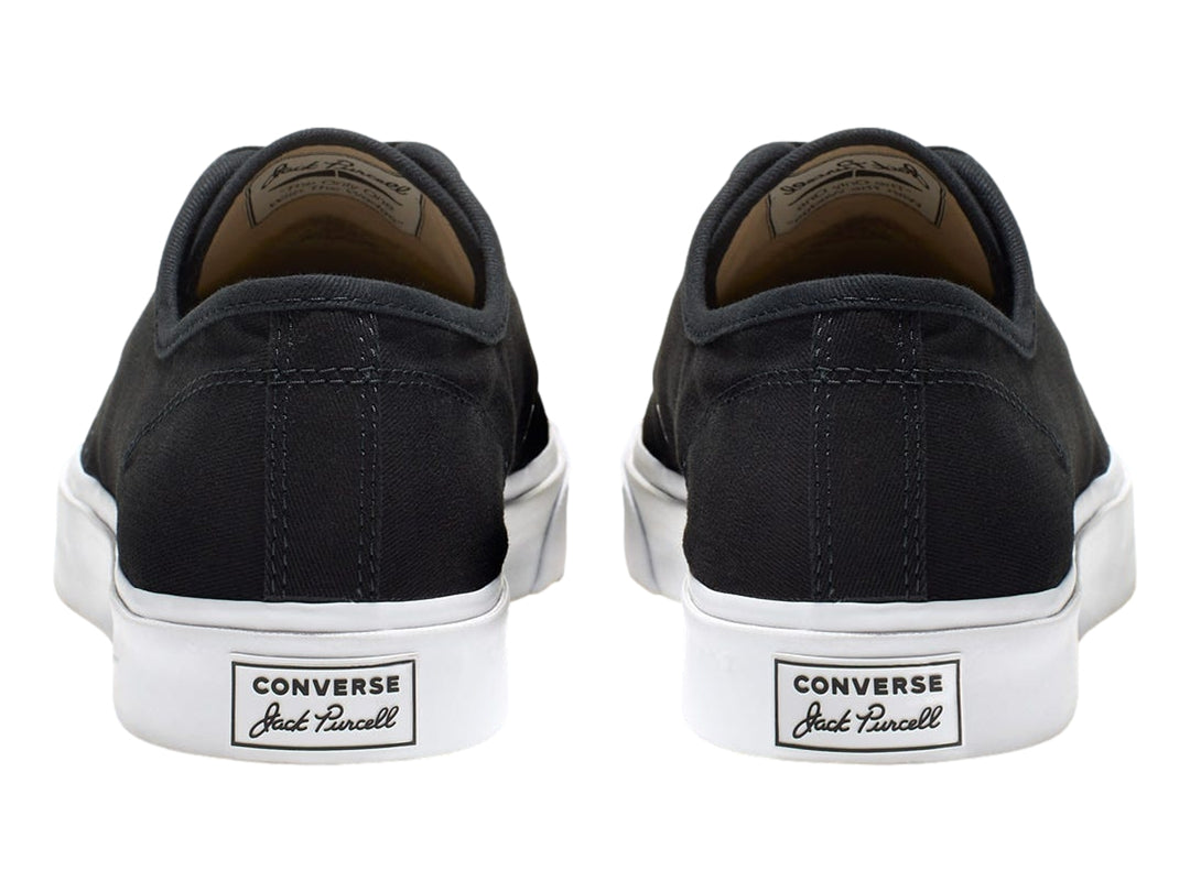 Tenis Converse Jack Purcell de color negro con suela y punta blanca, vista lateral.