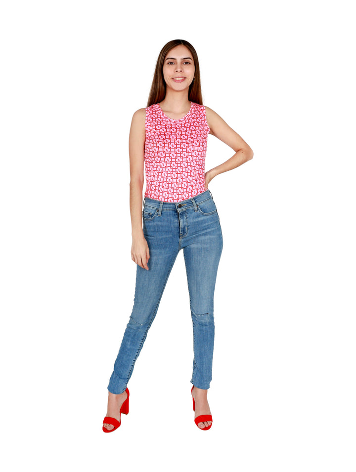 Mujer vistiendo una pantiblusa rosa con estampado geométrico rojo y pantalones de mezclilla azules.