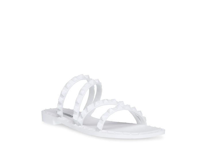 Sandalia blanca de Steve Madden con correas frontales decoradas con bordes dentados y suela plana.
