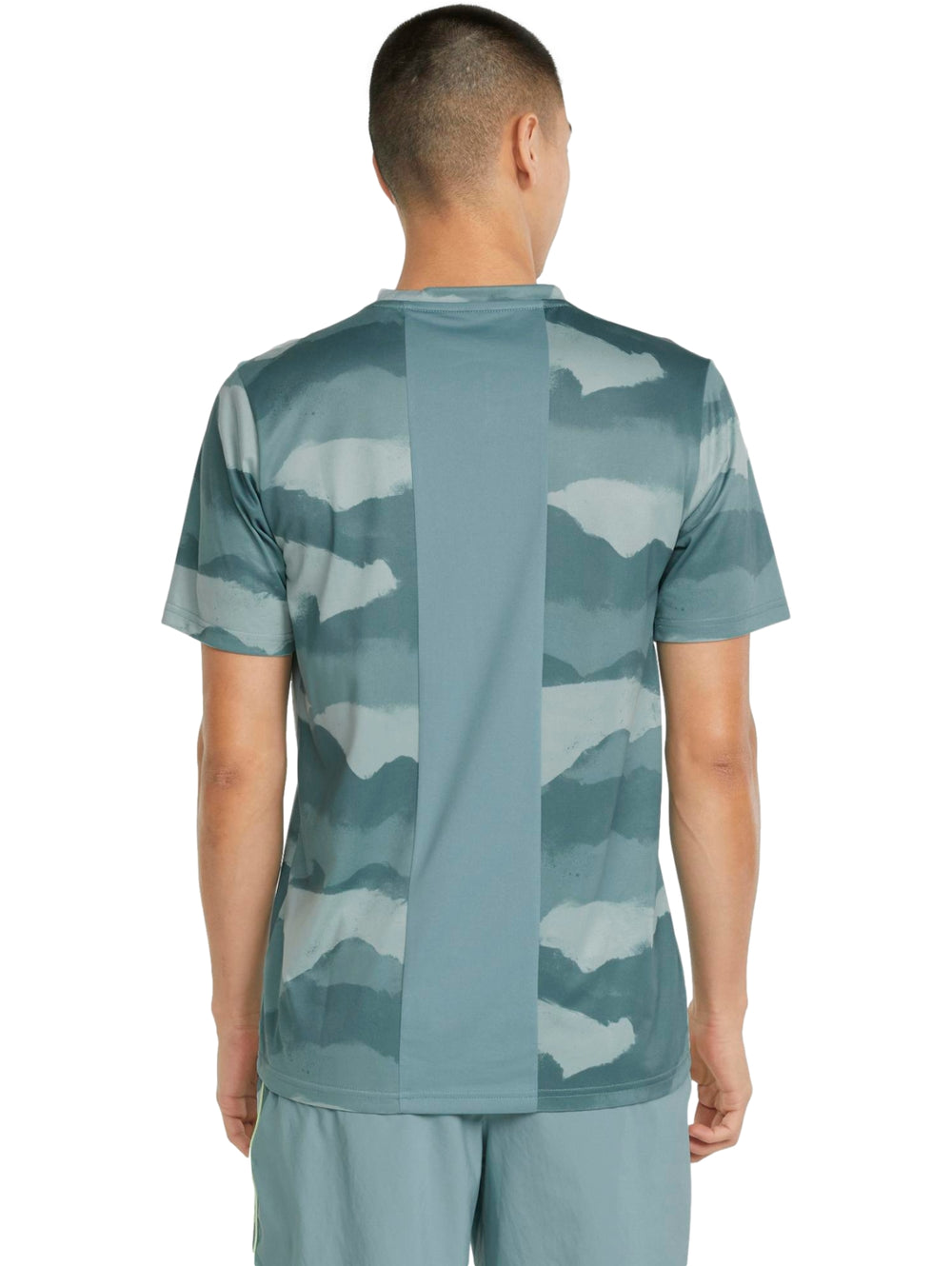 Hombre vistiendo camiseta deportiva PUMA color mineral blue con estampado abstracto en tonos azules y verdes.