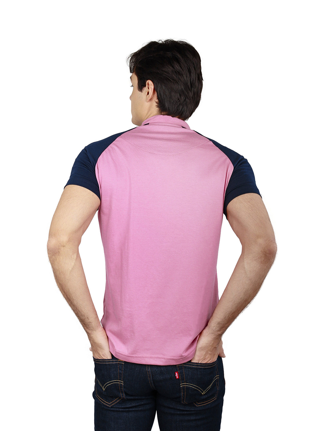 Hombre vistiendo playera de manga corta color rosa con mangas azul marino.