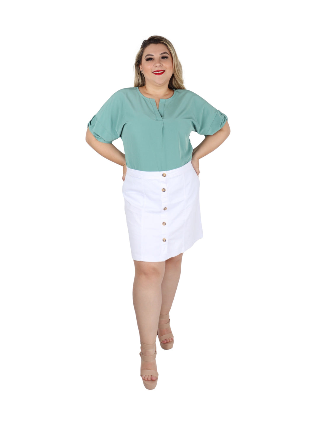 Mujer vistiendo una falda corta de gabardina color blanco con botones frontales.