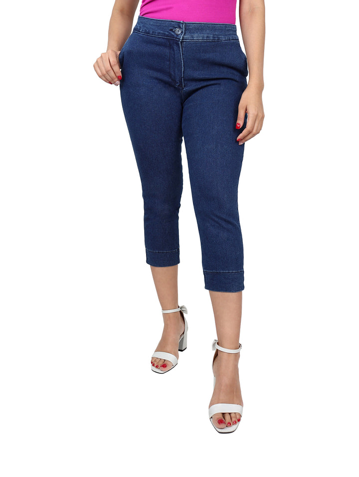 Mujer vistiendo pantalones capri de mezclilla en color azul oscuro.