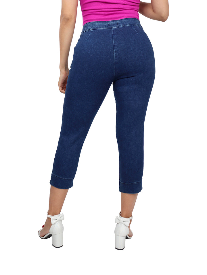 Mujer vistiendo pantalones capri de mezclilla en color azul oscuro.