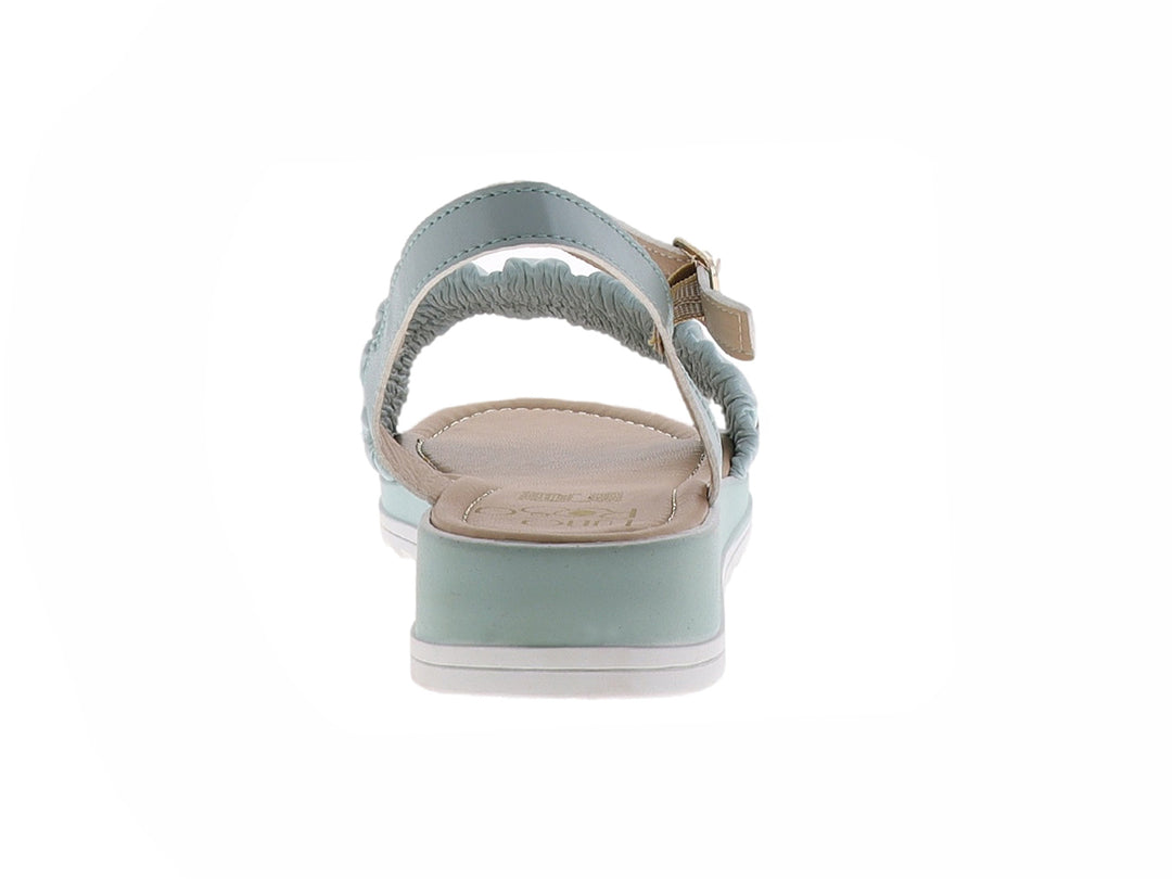 Sandalia color menta para mujer con correa ajustable al tobillo y banda frontal fruncida sobre suela blanca.