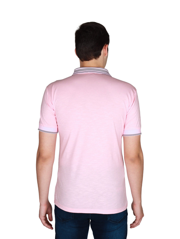 Hombre vistiendo playera polo color rosa con detalles de rayas oscuras en cuello y mangas.