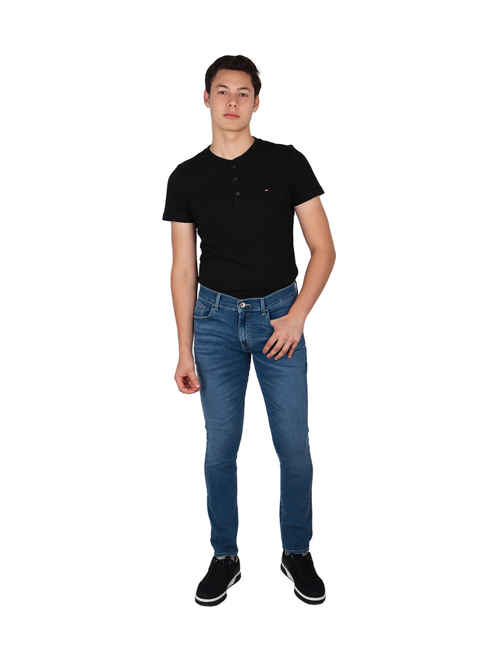 Hombre vistiendo pantalones jeans color azul stone europeo y playera polo negra.