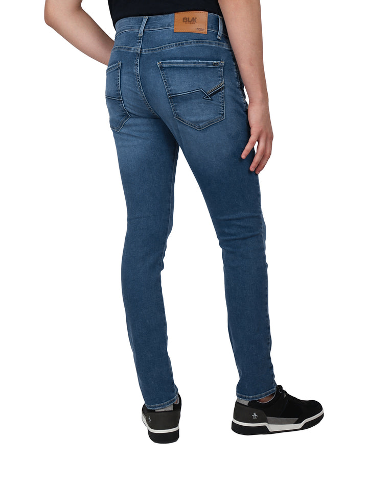 Hombre vistiendo pantalones jeans color azul stone europeo y playera polo negra.