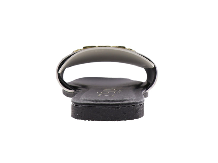 Sandalia casual para mujer en colores hueso y negro con hebilla dorada decorativa.