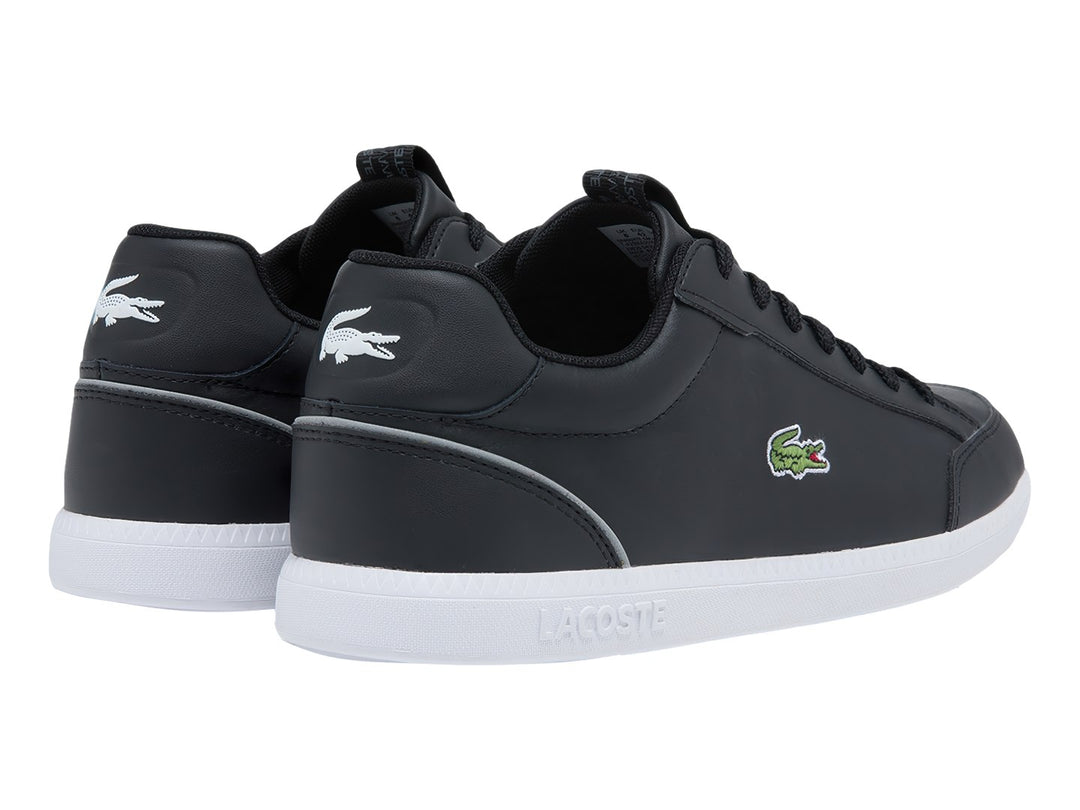 Tenis Lacoste color negro con suela blanca y logotipo del cocodrilo en el lateral.