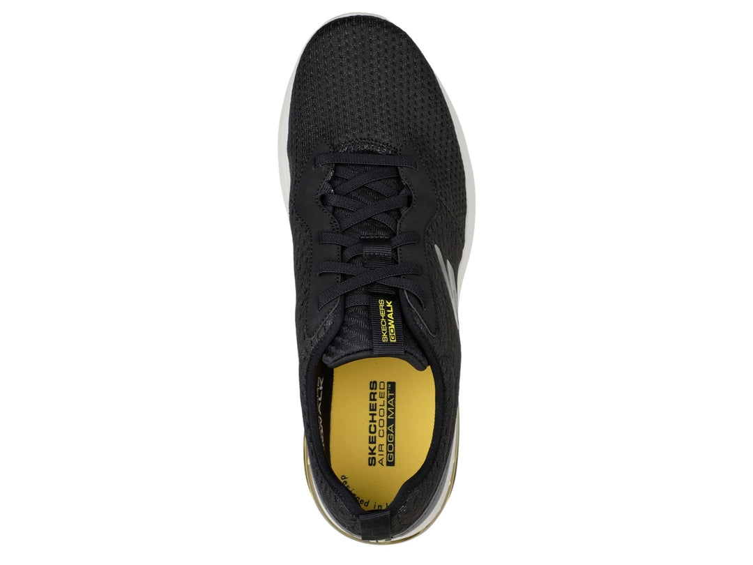Tenis deportivos Skechers color negro con suela blanca y amortiguación amarilla en el talón.