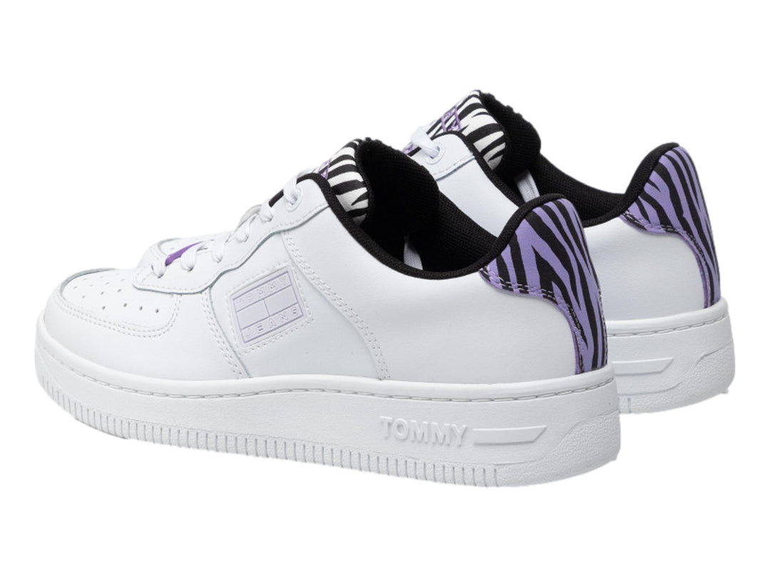 Tenis Tommy Hilfiger color blanco con detalles en estampado de cebra morado y negro en el talón y lengüeta.