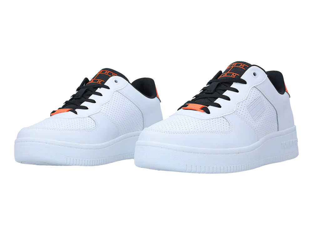Tenis blancos Tommy Hilfiger con detalles en naranja y negro, diseño deportivo de corte bajo.