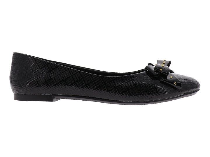 Zapato plano negro brillante para niña con moño decorado con tachuelas doradas.