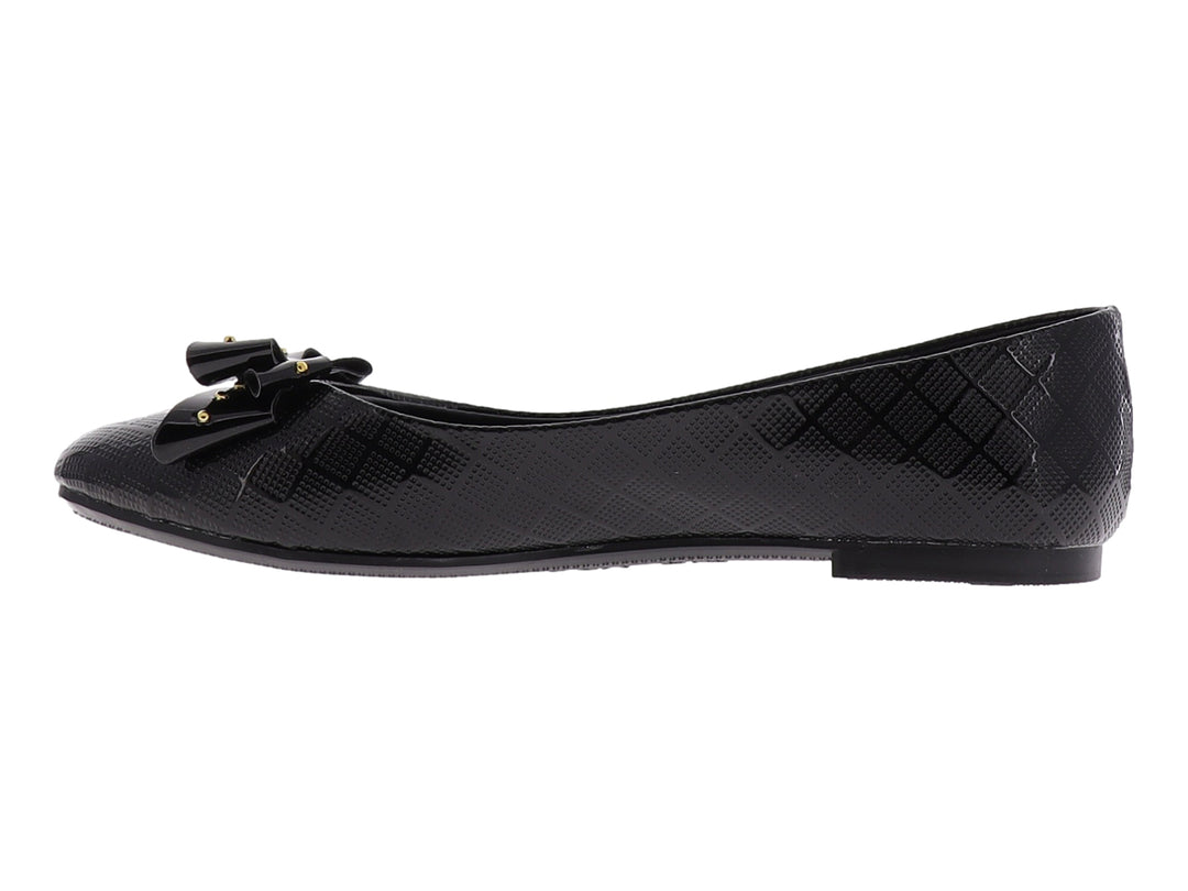 Zapato plano negro brillante para niña con moño decorado con tachuelas doradas.
