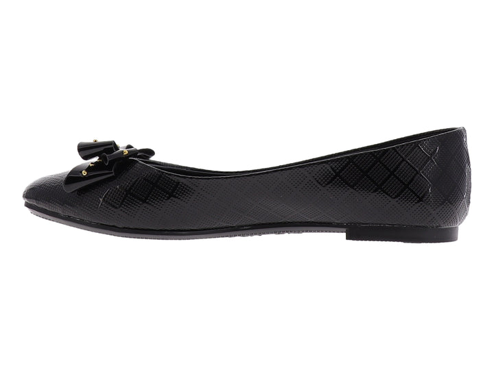 Zapato plano negro brillante para niña con moño decorado con tachuelas doradas.