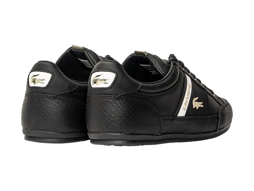 Tenis Lacoste color negro para hombre con franja blanca lateral y logotipo dorado.