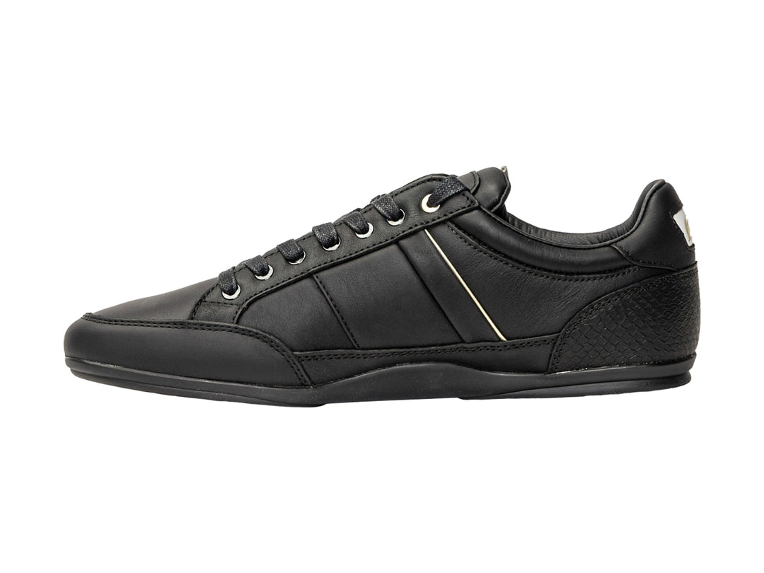 Tenis Lacoste color negro para hombre con franja blanca lateral y logotipo dorado.