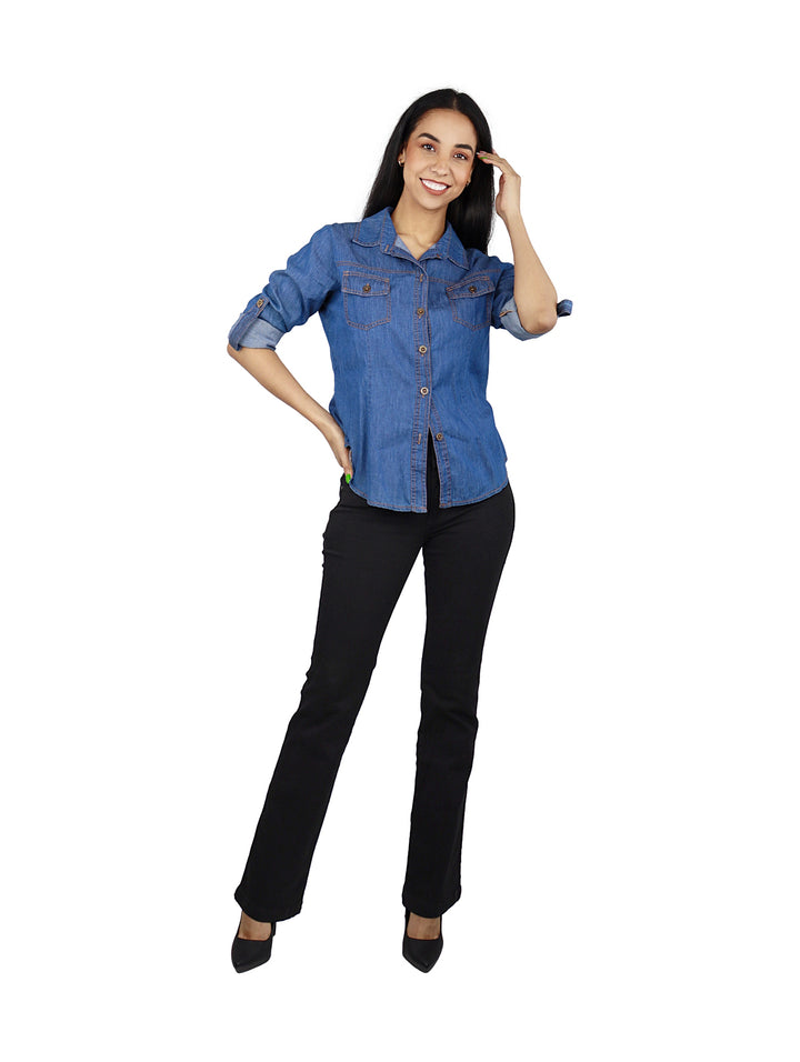 Mujer vistiendo jeans rectos de color negro con botones frontales y calzado oscuro.