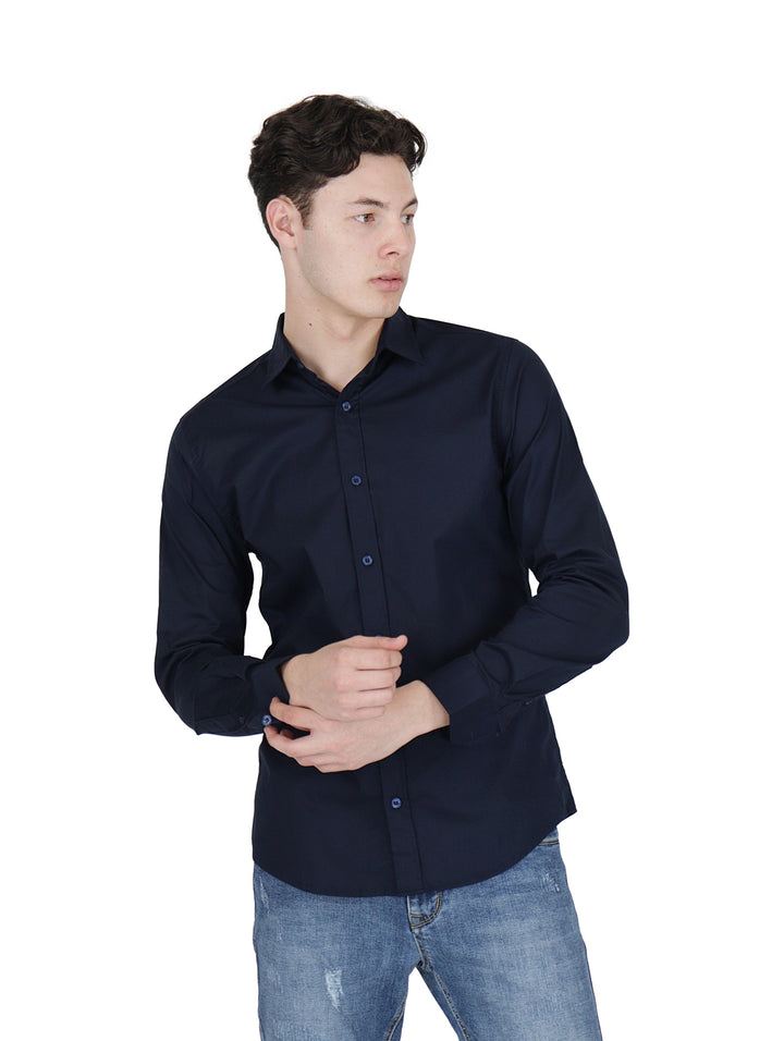 Hombre vistiendo una camisa de manga larga color azul marino y pantalones de mezclilla.