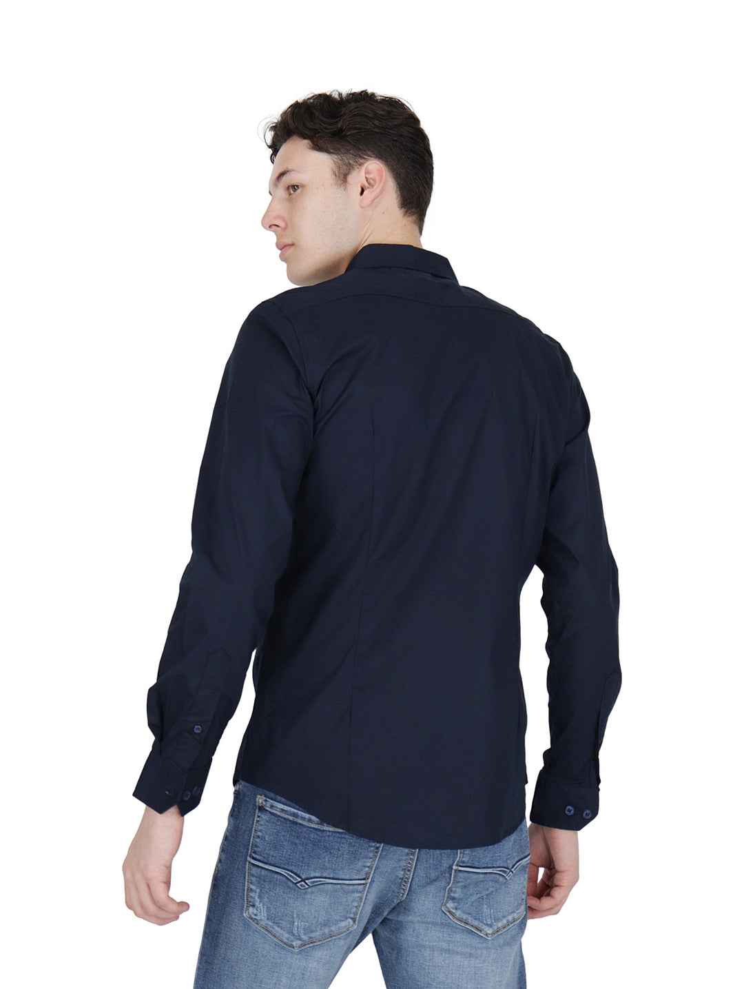 Hombre vistiendo una camisa de manga larga color azul marino y pantalones de mezclilla.