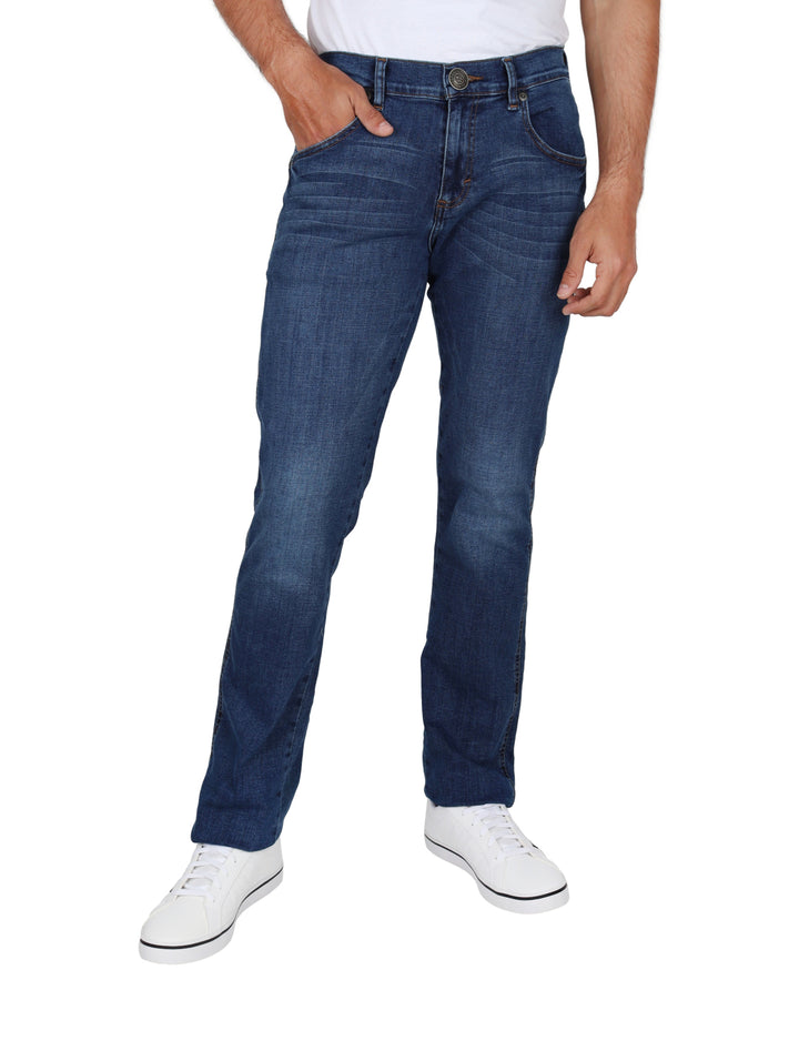 Hombre vistiendo pantalones Wrangler de color índigo y tenis blancos.