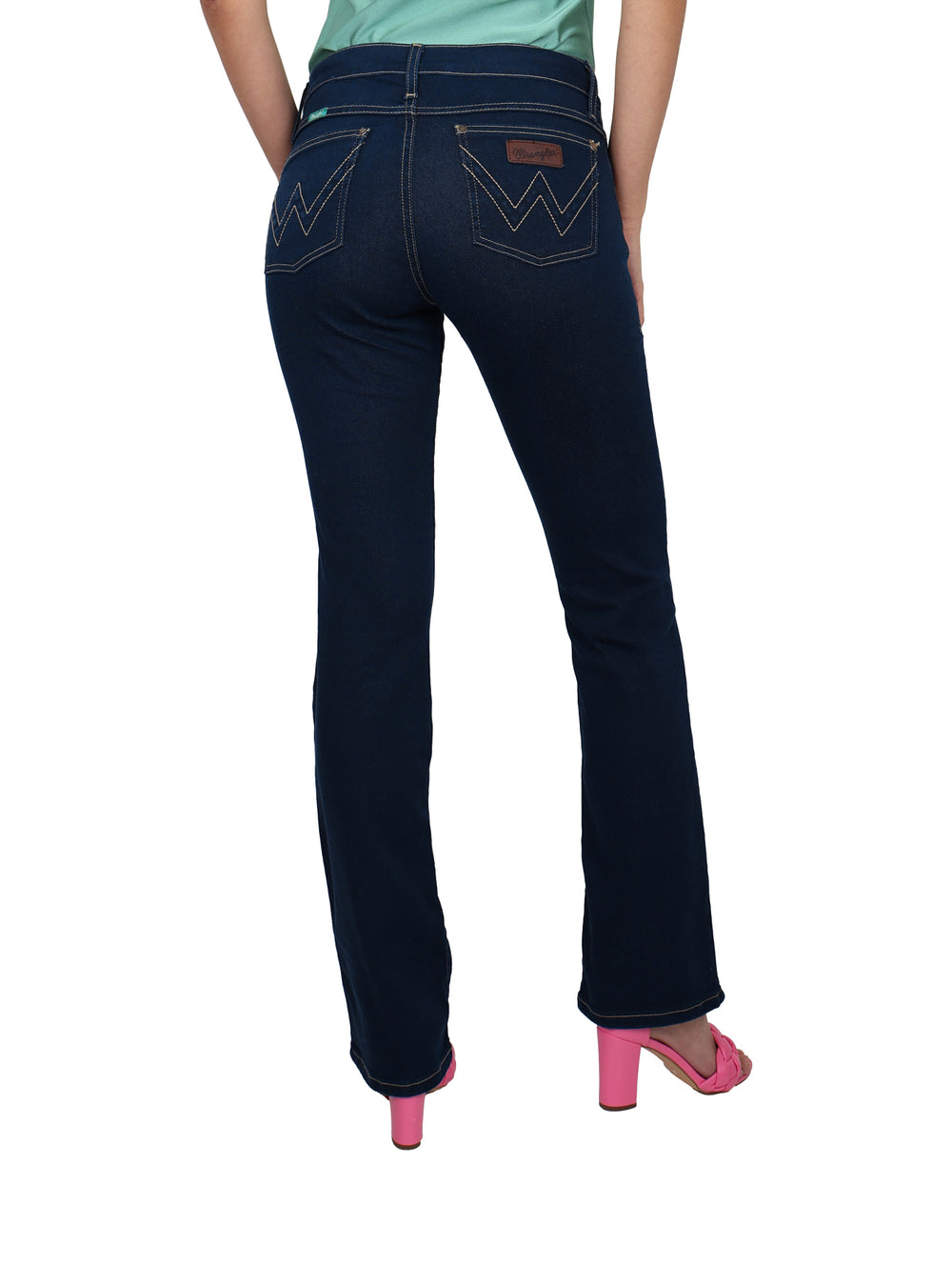 Mujer vistiendo pantalones Wrangler Western Low Rise en color índigo oscuro y sandalias rosas.