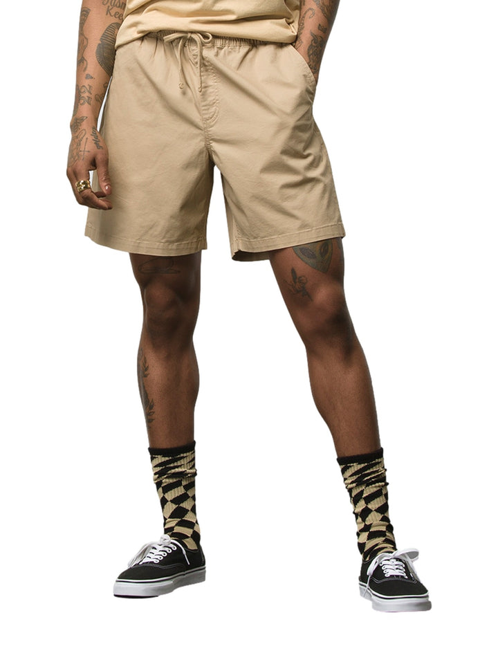 Hombre vistiendo pantalones cortos VANS color khaki con cintura elástica y cordón.