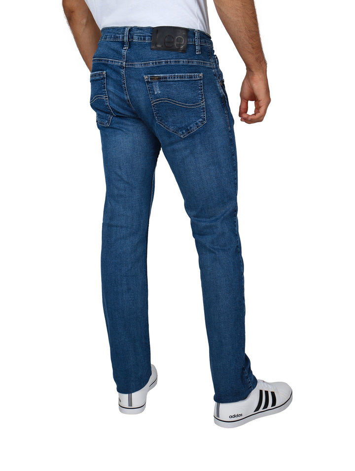 Hombre vistiendo pantalones LEE skinny de color índigo y tenis blancos.