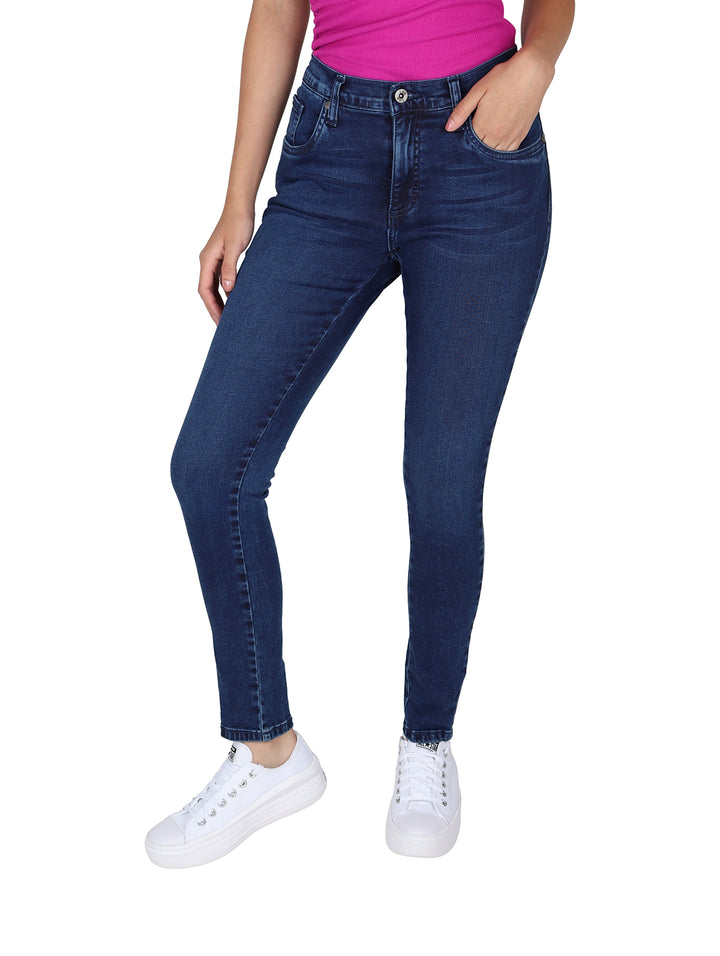 Mujer vistiendo pantalones LEE skinny jeans de color índigo, cintura alta y tenis blancos.