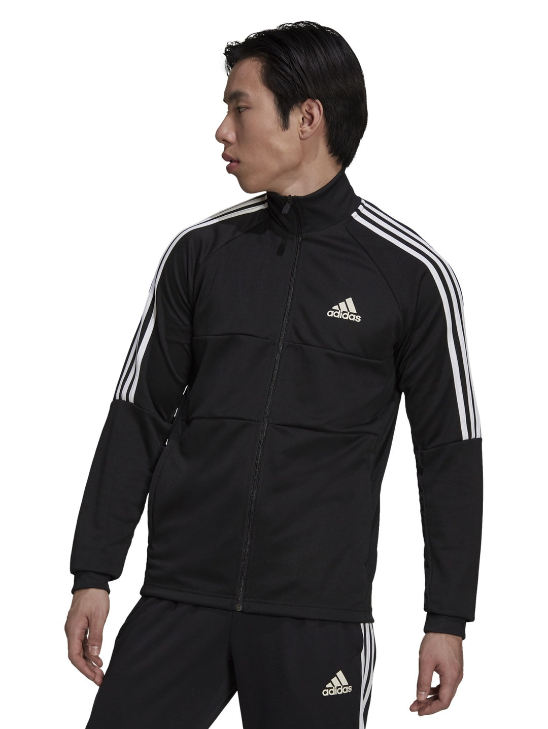 Hombre vistiendo chaqueta deportiva Adidas Aeroready Sereno Cut color negro con rayas blancas laterales.