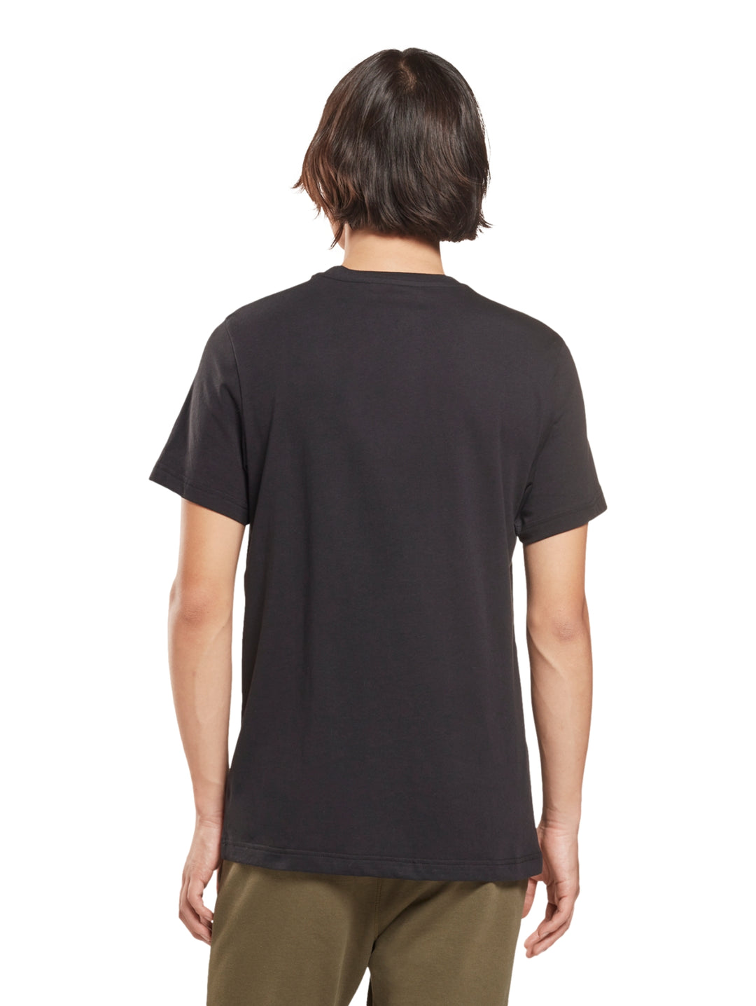 Hombre usando playera negra de manga corta con logotipo blanco de Reebok en el pecho.