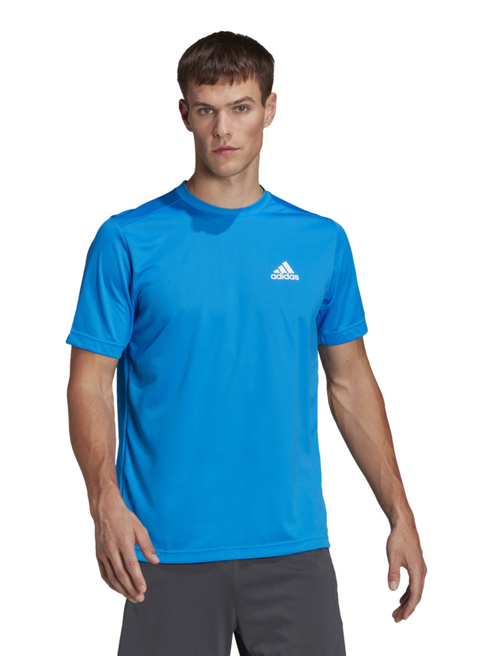 Hombre vistiendo una playera deportiva Adidas de color azul rush con logo blanco en el pecho.