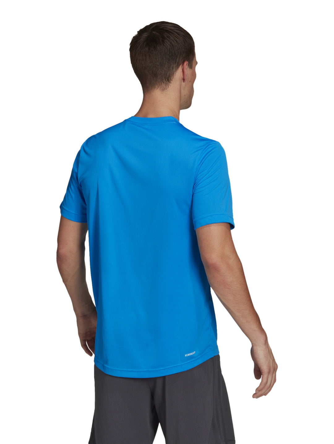 Hombre vistiendo una playera deportiva Adidas de color azul rush con logo blanco en el pecho.
