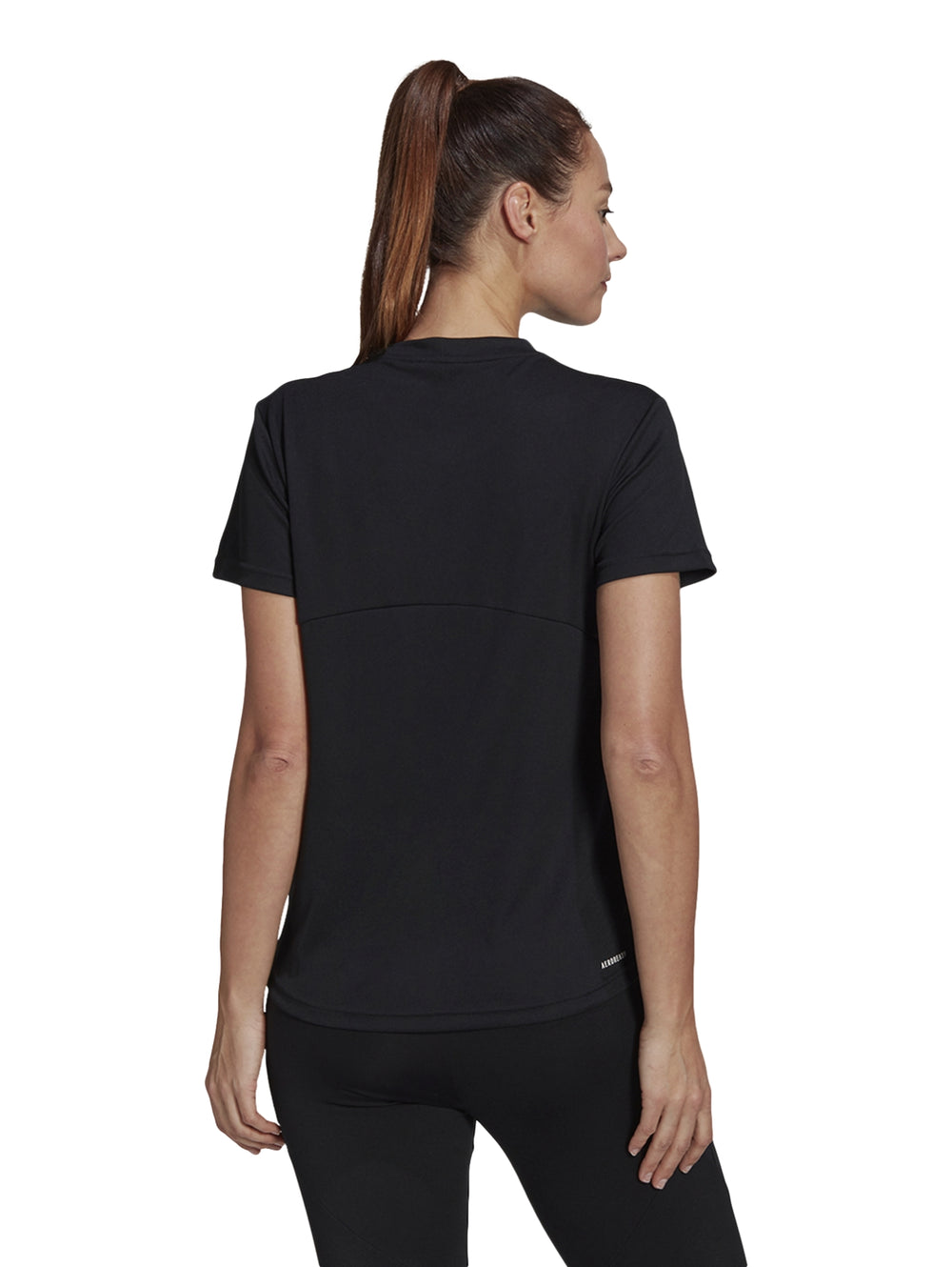 Mujer vistiendo una playera deportiva Adidas de color negro con logo blanco en el pecho.