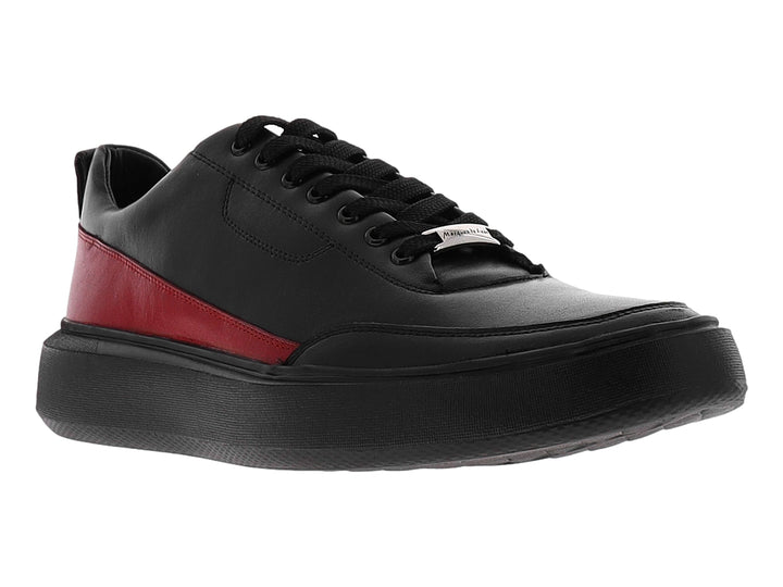 Zapato casual negro con detalle lateral en color rojo y suela ancha negra.