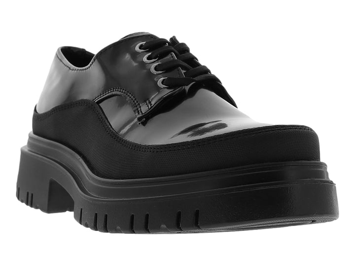 Zapato Oxford negro para mujer con acabado en charol y suela de plataforma gruesa.