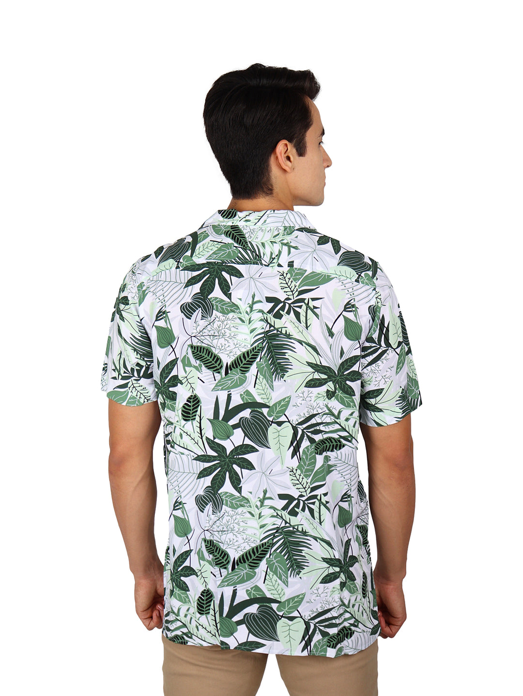 Hombre vistiendo camisa de manga corta blanca con estampado de hojas tropicales verdes.