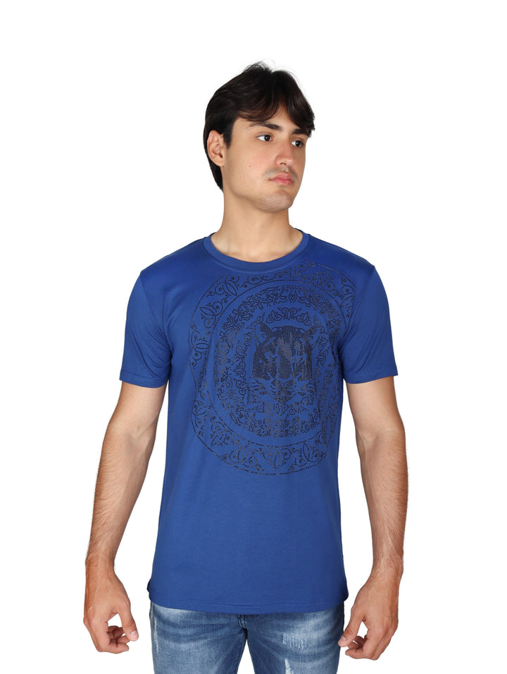 Hombre vistiendo playera azul royal de manga corta con estampado circular en el pecho y cuello redondo.
