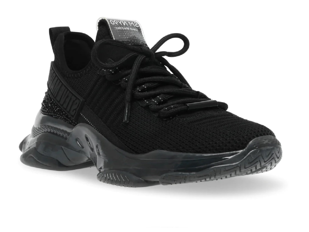 Tenis Steve Madden color negro con suela gruesa brillante y parte superior de malla.
